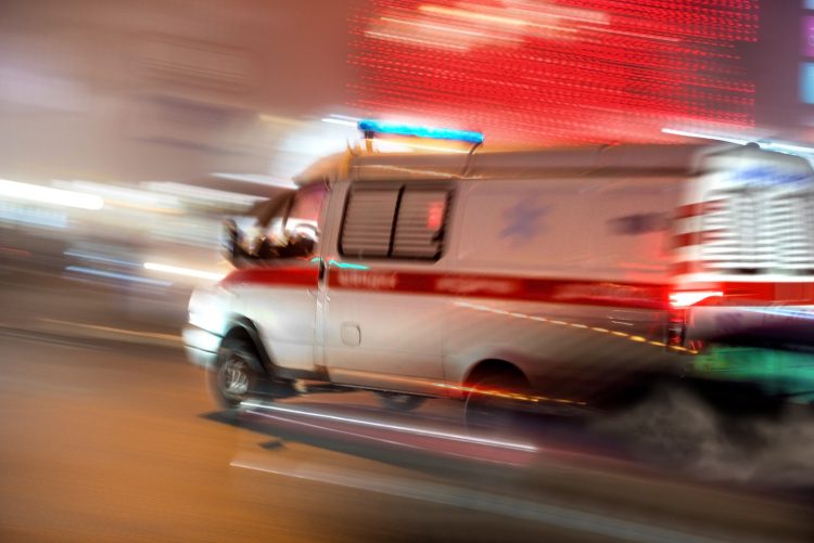 Ambulance in motion driving down the road at night. Intentional motion blur